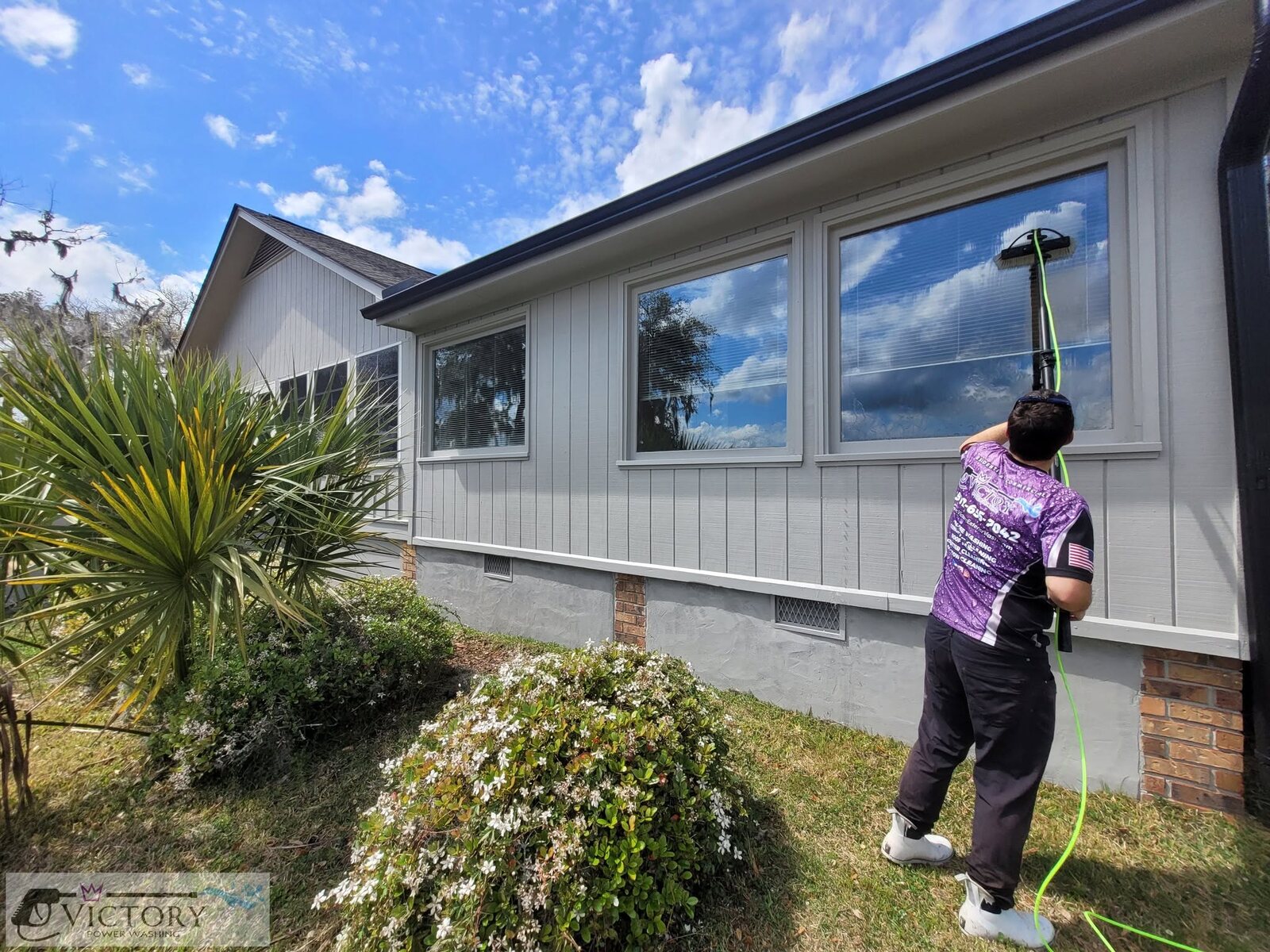 Victory technician cleaning residential exterior windows